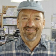 Warren Lee Man with salt-and-pepper goatee and beard in a print shop
